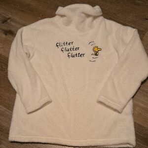 Cozy Cream Turtleneck Sweater with Embroidered 'Flutter' Accent